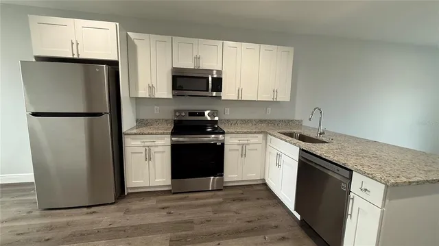 a kitchen with a refrigerator sink and white cabinets
