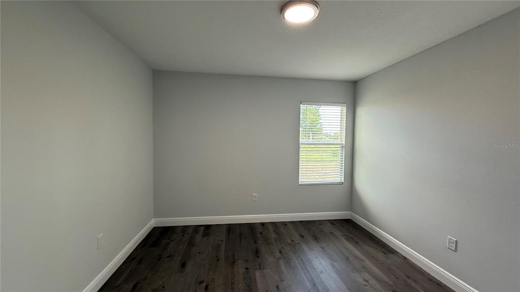 11079 Kimberly Avenue Englewood, FL 34224 - Photo 7 of 14 a view of an empty room with wooden floor and a window