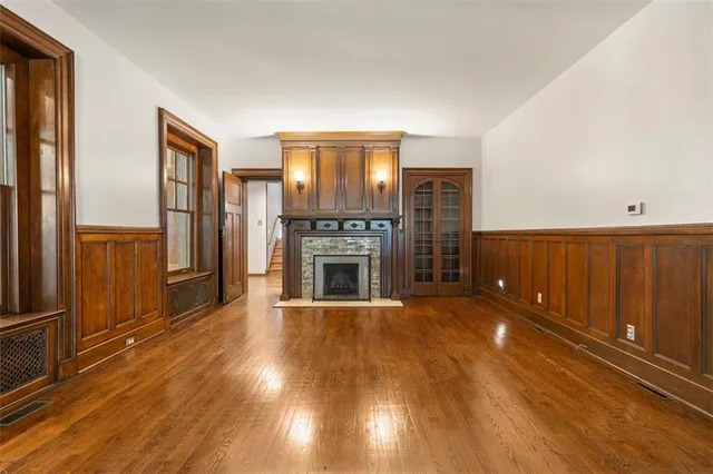a view of a livingroom with a fireplace window and wooden floor