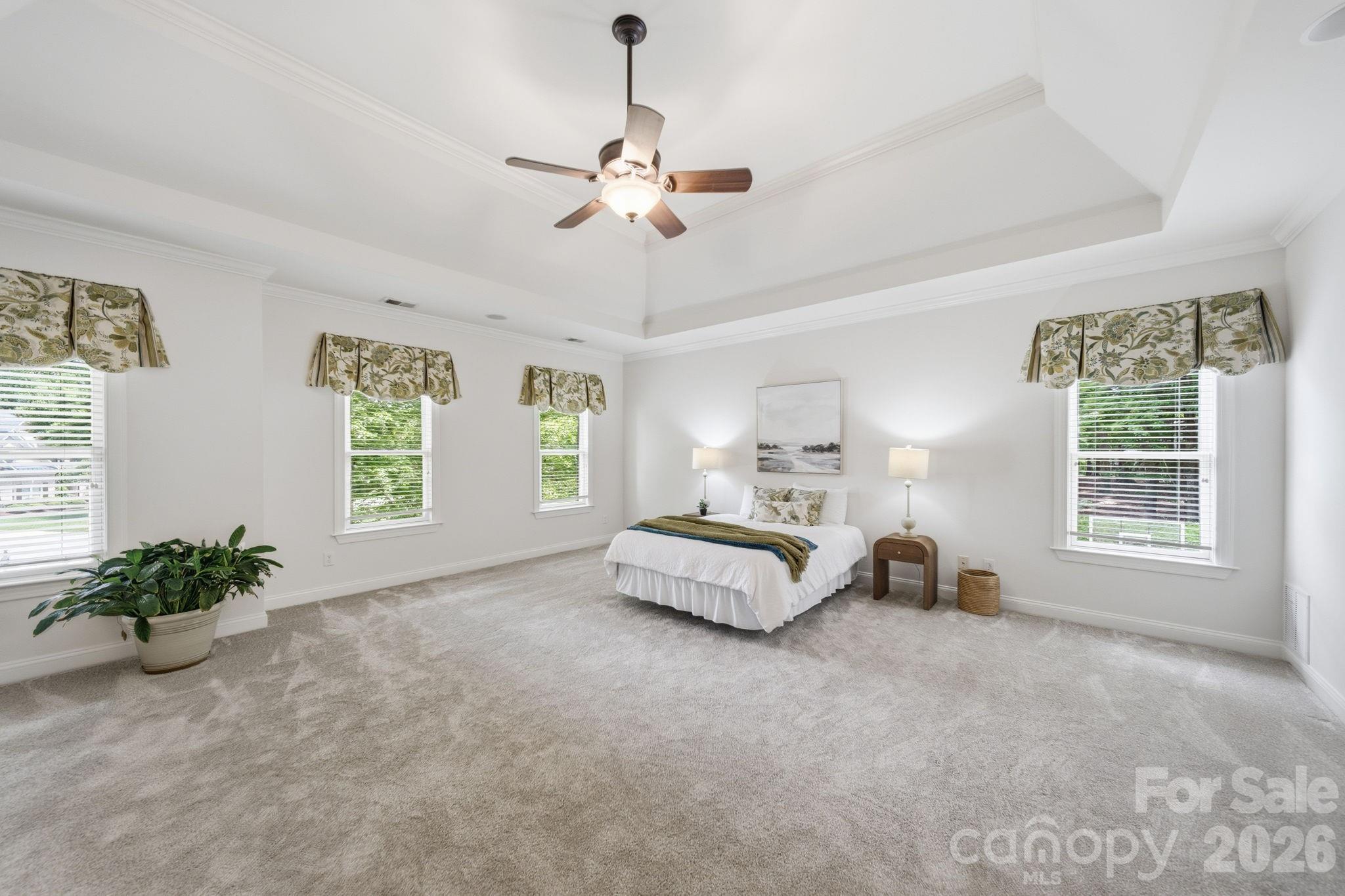 1802 Summit View Place Waxhaw, NC 28173 - Photo 19 of 47 a spacious bedroom with a bed a chandelier and a window