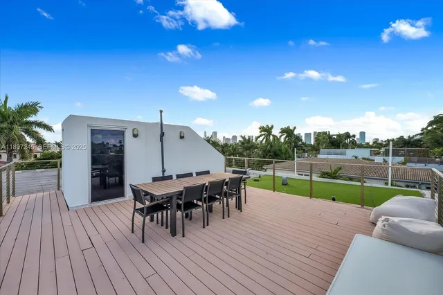 a view of a roof deck with table and chairs with wooden floor and fence