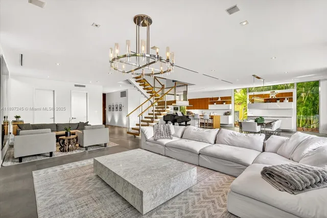 a living room with furniture chandelier and kitchen view