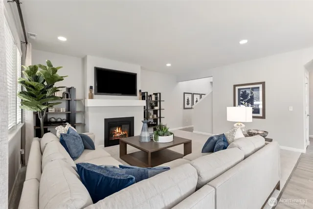 a living room with furniture a fireplace and a flat screen tv