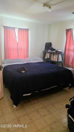 a bed sitting in a bedroom next to a window