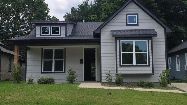 a view of a brick house with a large windows and a yard