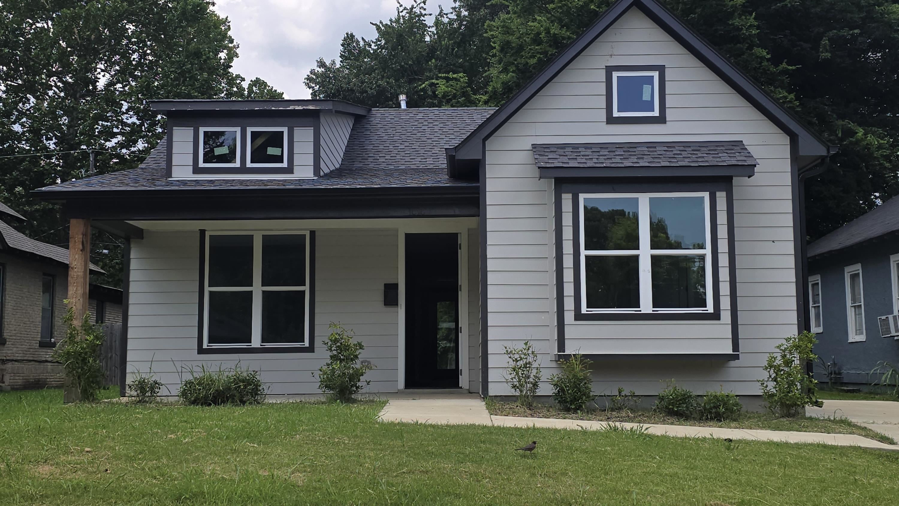 a view of a brick house with a large windows and a yard