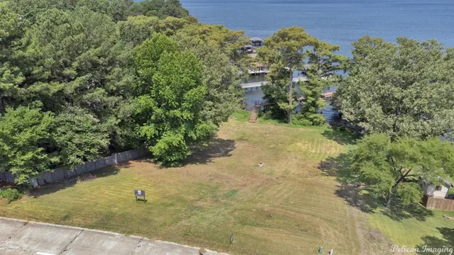 an aerial view of a house with a yard and lake view