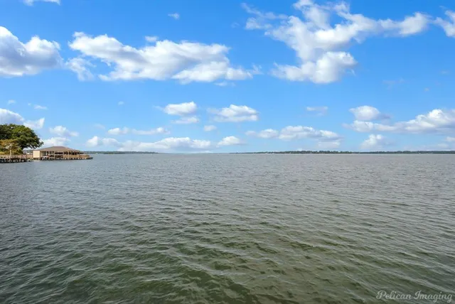 a view of a balcony with wooden floor and lake view