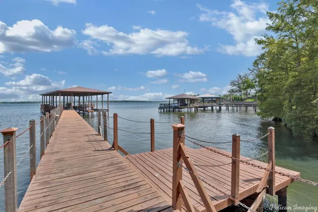 a patio with wooden floor a barbeque grill with dining table and chairs
