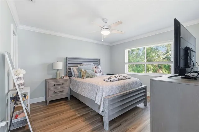 a bedroom with a bed and a flat tv screen on dresser