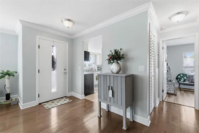 a view of a hallway with wooden floor and dining room