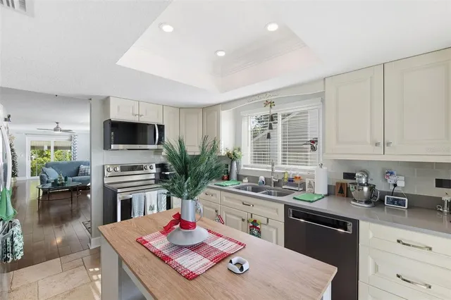 a kitchen with stainless steel appliances kitchen island granite countertop a sink stove and cabinets