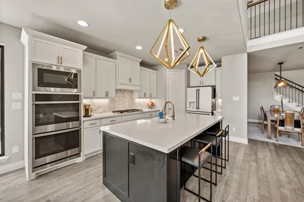 a kitchen with a sink stainless steel appliances and white cabinets