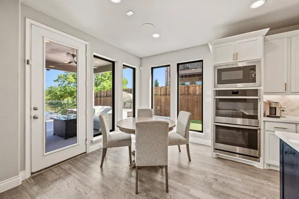 a dining room with furniture a fireplace and wooden floor