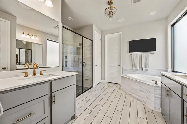 a spacious bathroom with a double vanity sink a mirror and shower