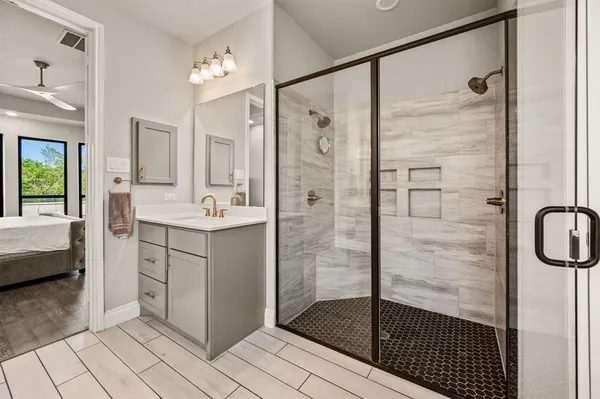 a bathroom with a shower sink and mirror