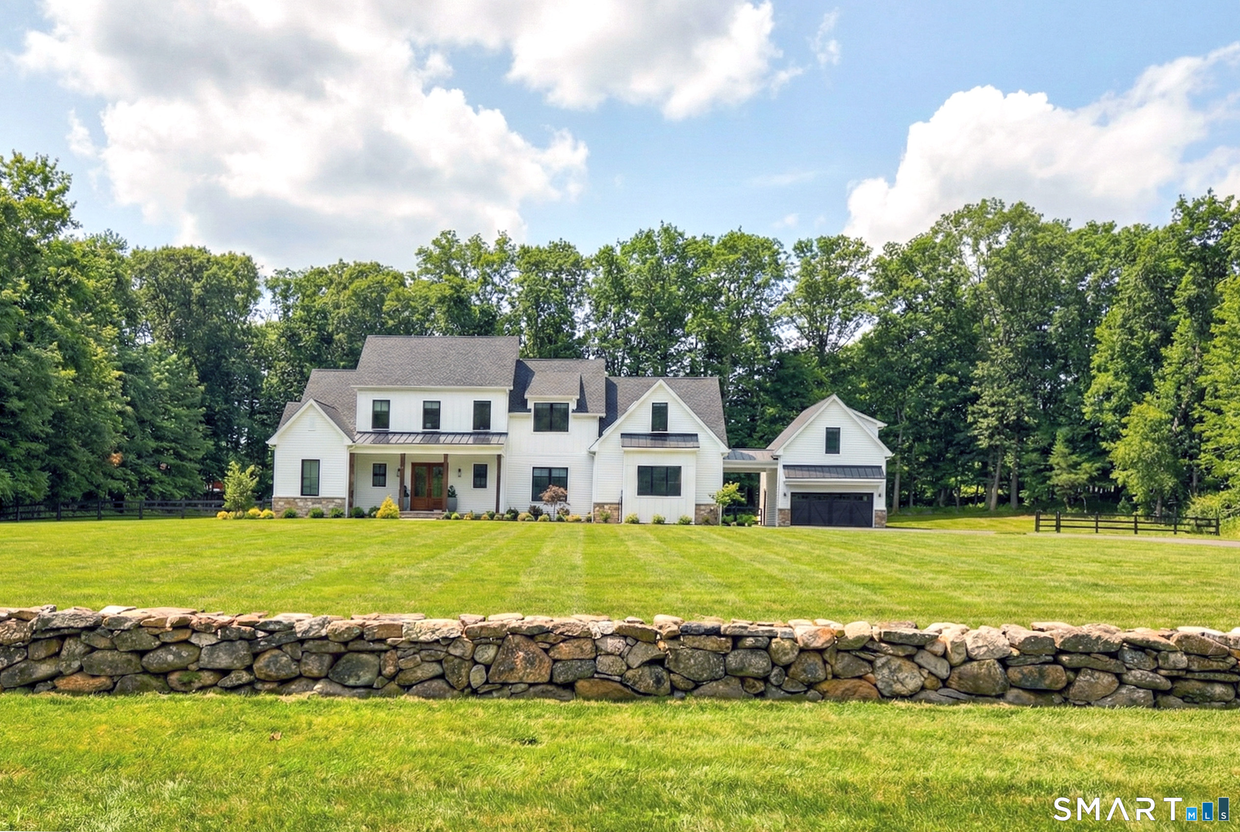 a view of a house with a big yard and large trees