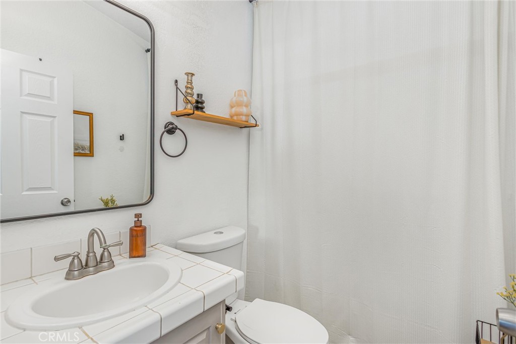 8681 Katella Avenue, Unit 897 Stanton, CA 90680 - Photo 15 of 31 a bathroom with a toilet sink and mirror