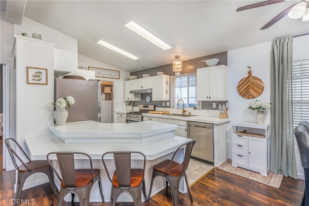 8681 Katella Avenue, Unit 897 Stanton, CA 90680 - Photo 9 of 31 a kitchen with a table chairs refrigerator and cabinets
