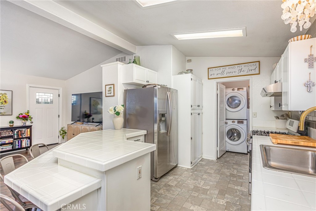 8681 Katella Avenue, Unit 897 Stanton, CA 90680 - Photo 10 of 31 a kitchen with stainless steel appliances a refrigerator a sink a stove and white cabinets