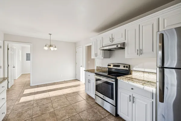 a kitchen with stainless steel appliances white cabinets and a stove top oven