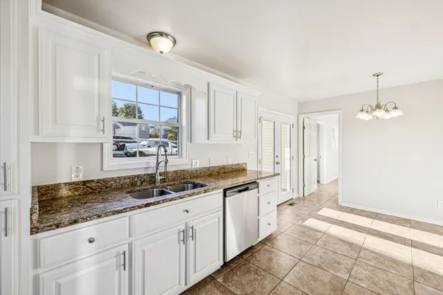 a kitchen with granite countertop a sink and cabinets