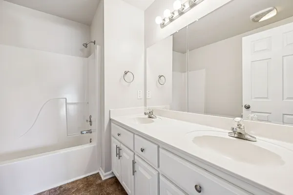 a bathroom with a sink double vanity granite tub shower and a mirror