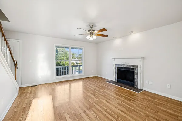 wooden floor fireplace and windows in an empty room