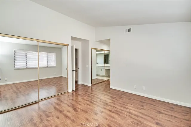 a view of empty room with wooden floor and cabinet