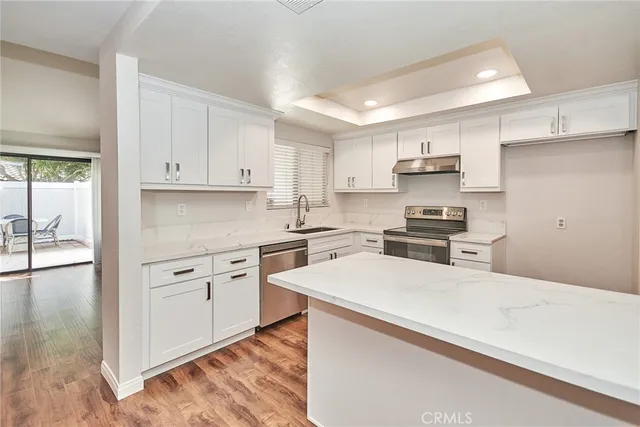 a kitchen with white cabinets and appliances