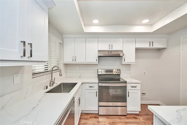 a kitchen with a sink stove top oven and cabinets