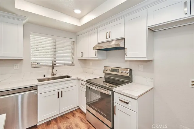 a kitchen with stainless steel appliances a sink stove and cabinets