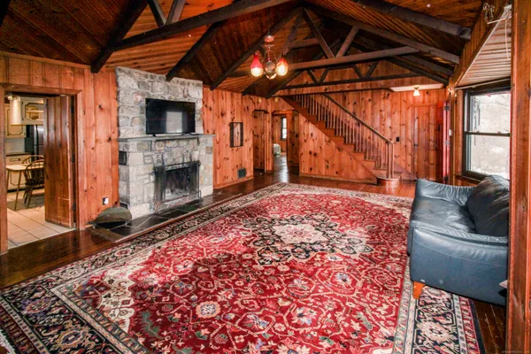 a view of an empty room with a fireplace and a rug