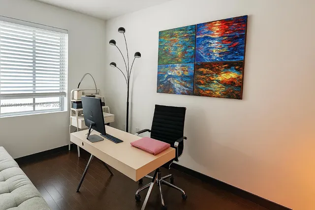 a view of a workspace with furniture and a window