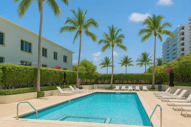 a view of swimming pool with outdoor seating and palm tree