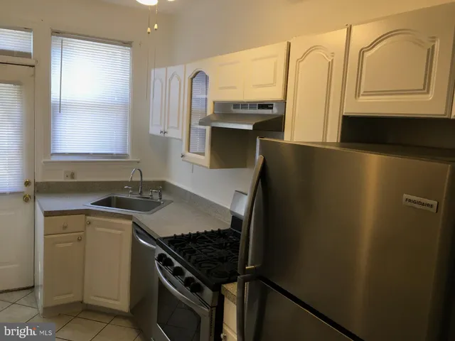 a kitchen with stainless steel appliances granite countertop a refrigerator and a stove