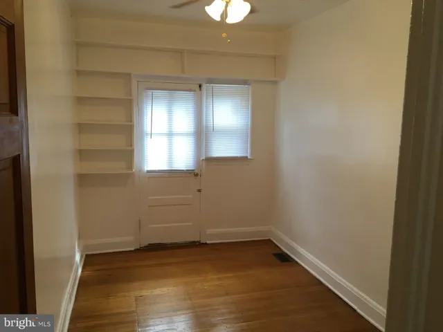 a view of empty room with wooden floor