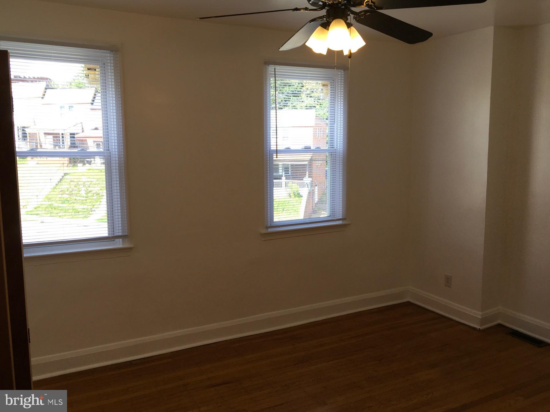 2477 West Cold Spring Lane Baltimore, MD 21215 - Photo 21 of 35 an empty room with wooden floor and windows