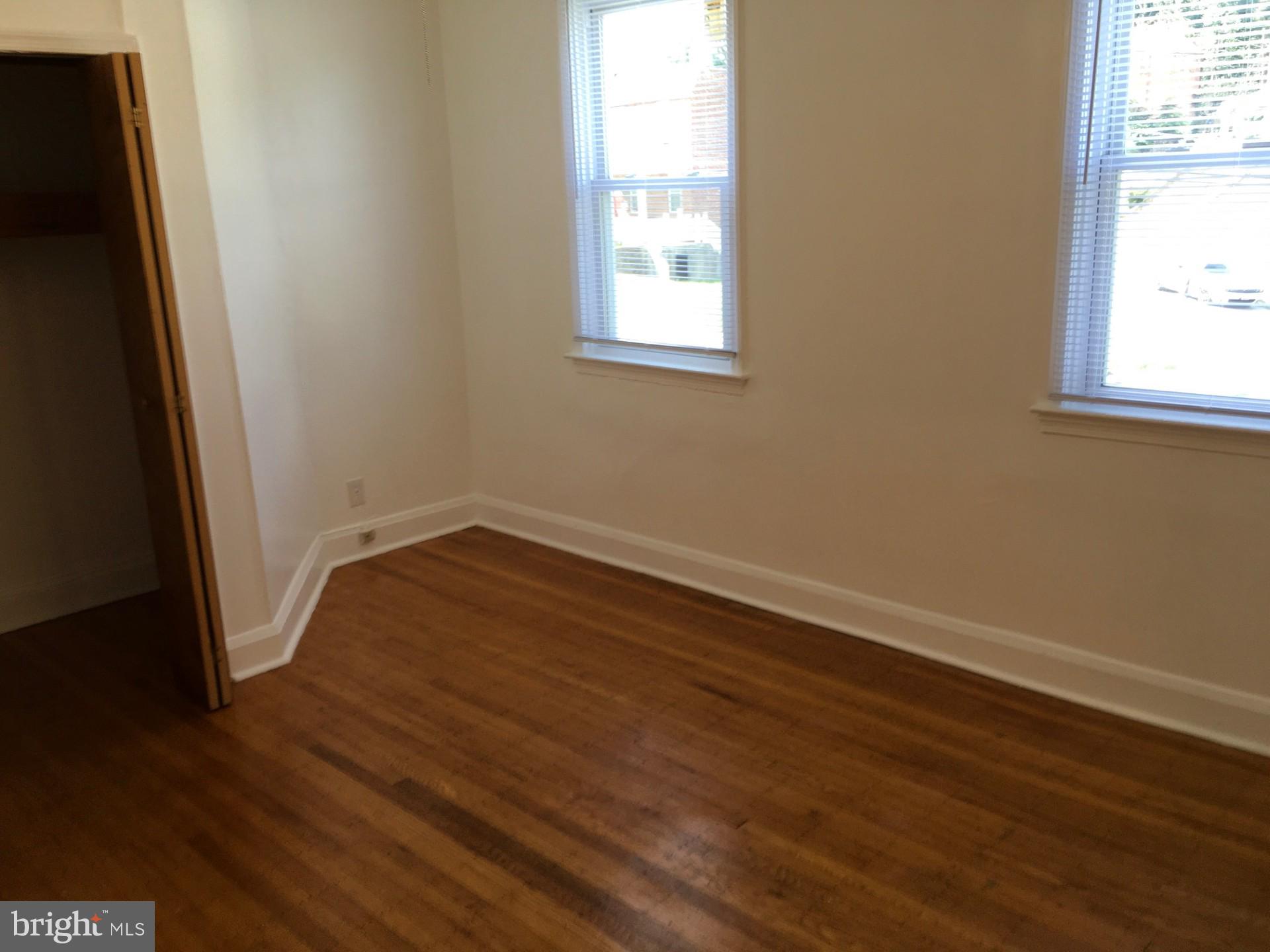 2477 West Cold Spring Lane Baltimore, MD 21215 - Photo 24 of 35 an empty room with wooden floor and windows
