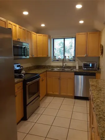 a kitchen with stainless steel appliances granite countertop a stove a sink and a microwave