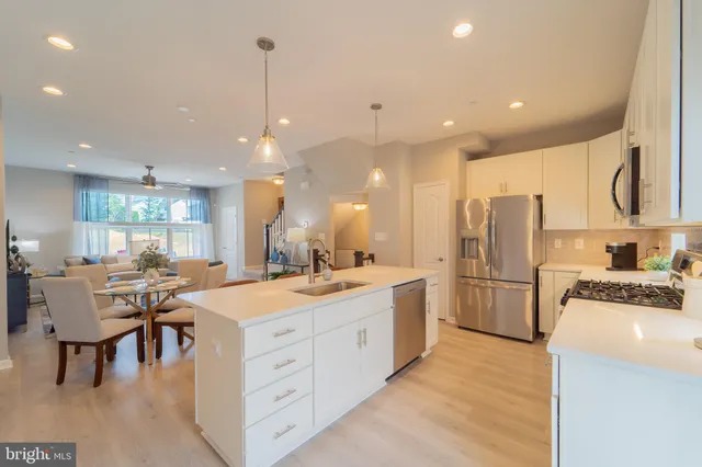 a large kitchen with kitchen island a sink a center island stainless steel appliances and a center island