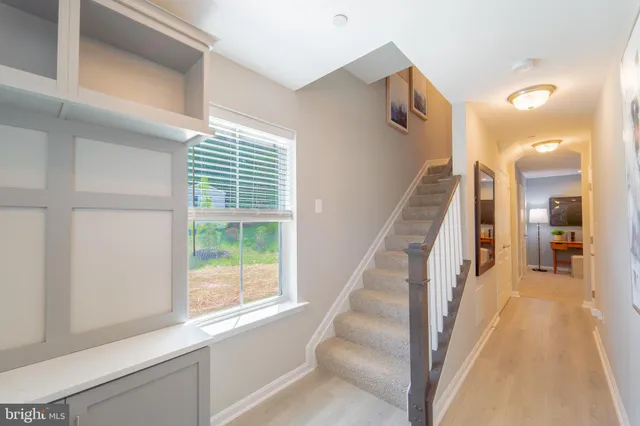 a view of a hallway with wooden floor and staircase