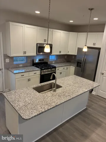 a kitchen with stainless steel appliances granite countertop a sink a stove and a microwave