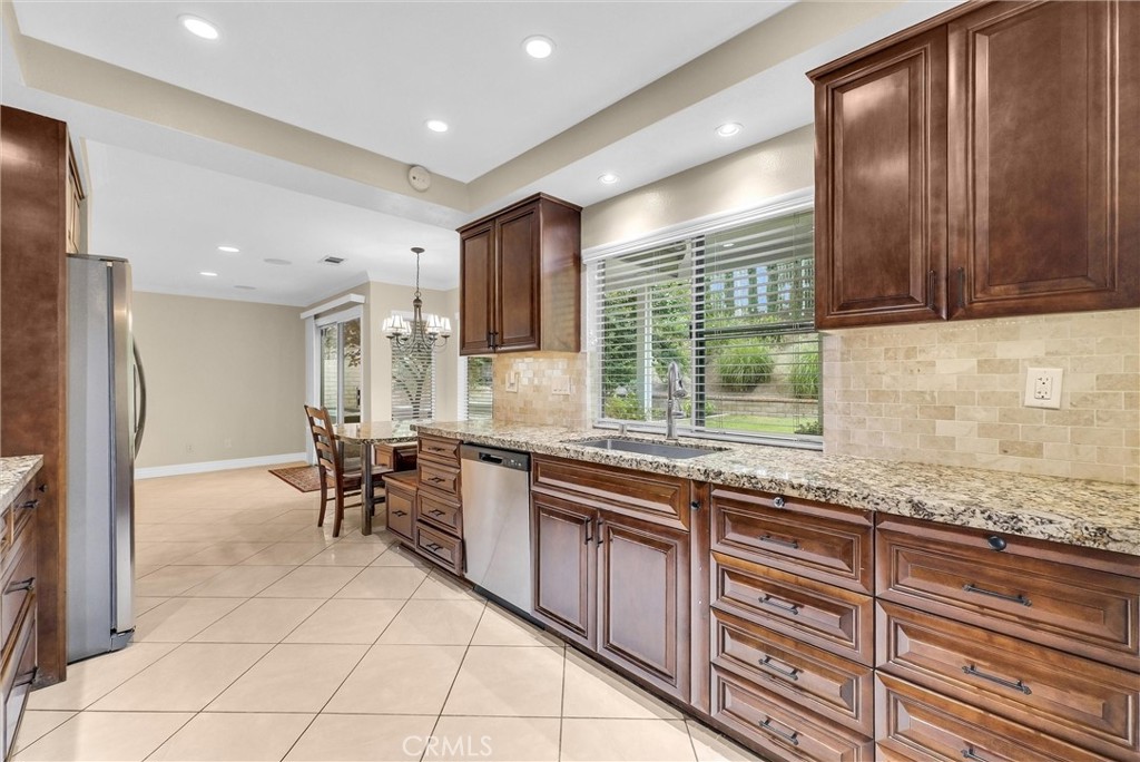 1070 Cannon Road Riverside, CA 92506 - Photo 22 of 53 a kitchen with stainless steel appliances granite countertop a stove a sink a oven with a dining table and chair
