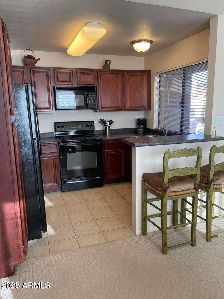 10115 East Mountain View Road, Unit 2036 Scottsdale, AZ 85258 - Photo 4 of 8 a kitchen with stainless steel appliances granite countertop a stove top oven a sink and a refrigerator