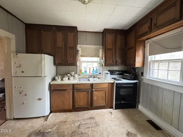 a kitchen with a refrigerator and a stove top oven