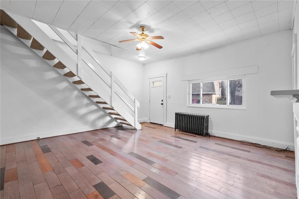 2012 Spring Street Pittsburgh, PA 15210 - Photo 6 of 20 a view of an empty room with wooden floor staircase and a living room