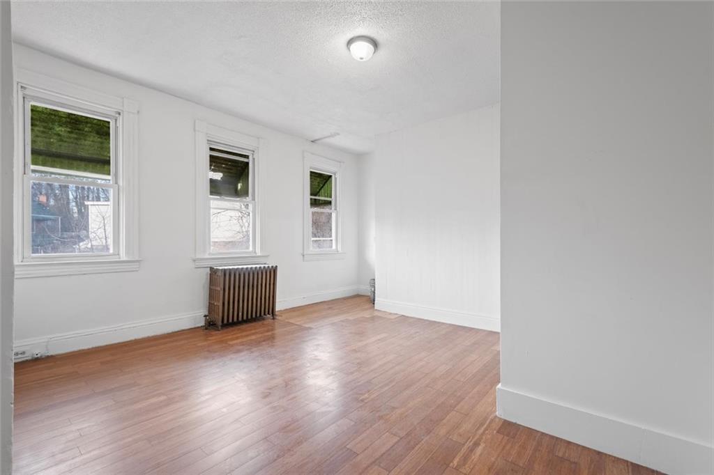 2012 Spring Street Pittsburgh, PA 15210 - Photo 8 of 20 an empty room with wooden floor and windows