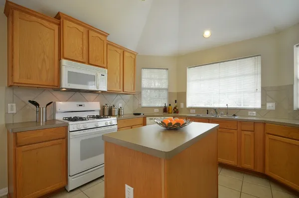 a kitchen with a sink a stove cabinets and a counter top space