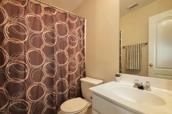 a bathroom with a sink and mirror with toilet
